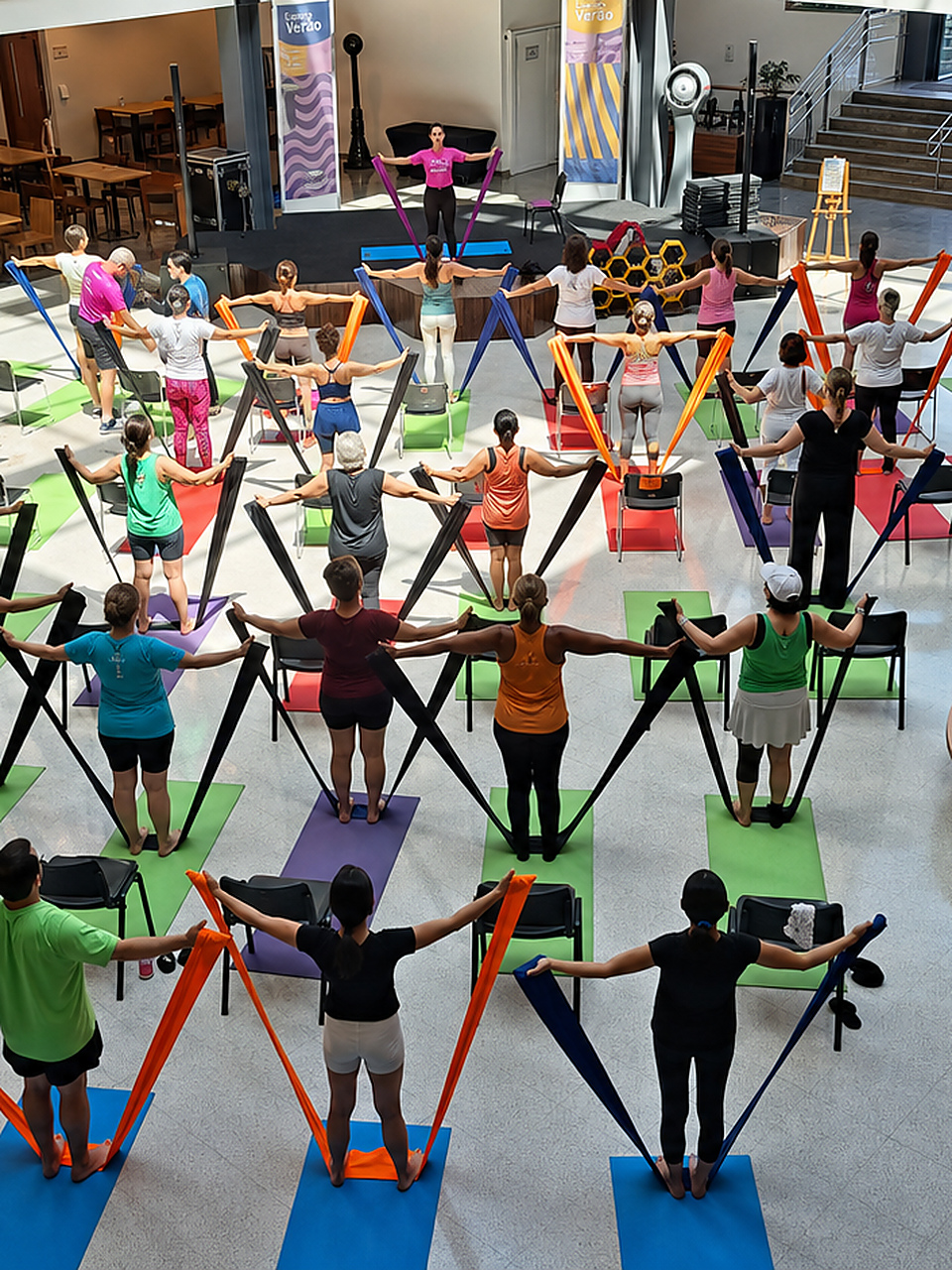 Aula coletiva Infinity Bands com participantes em colchonetes coloridos